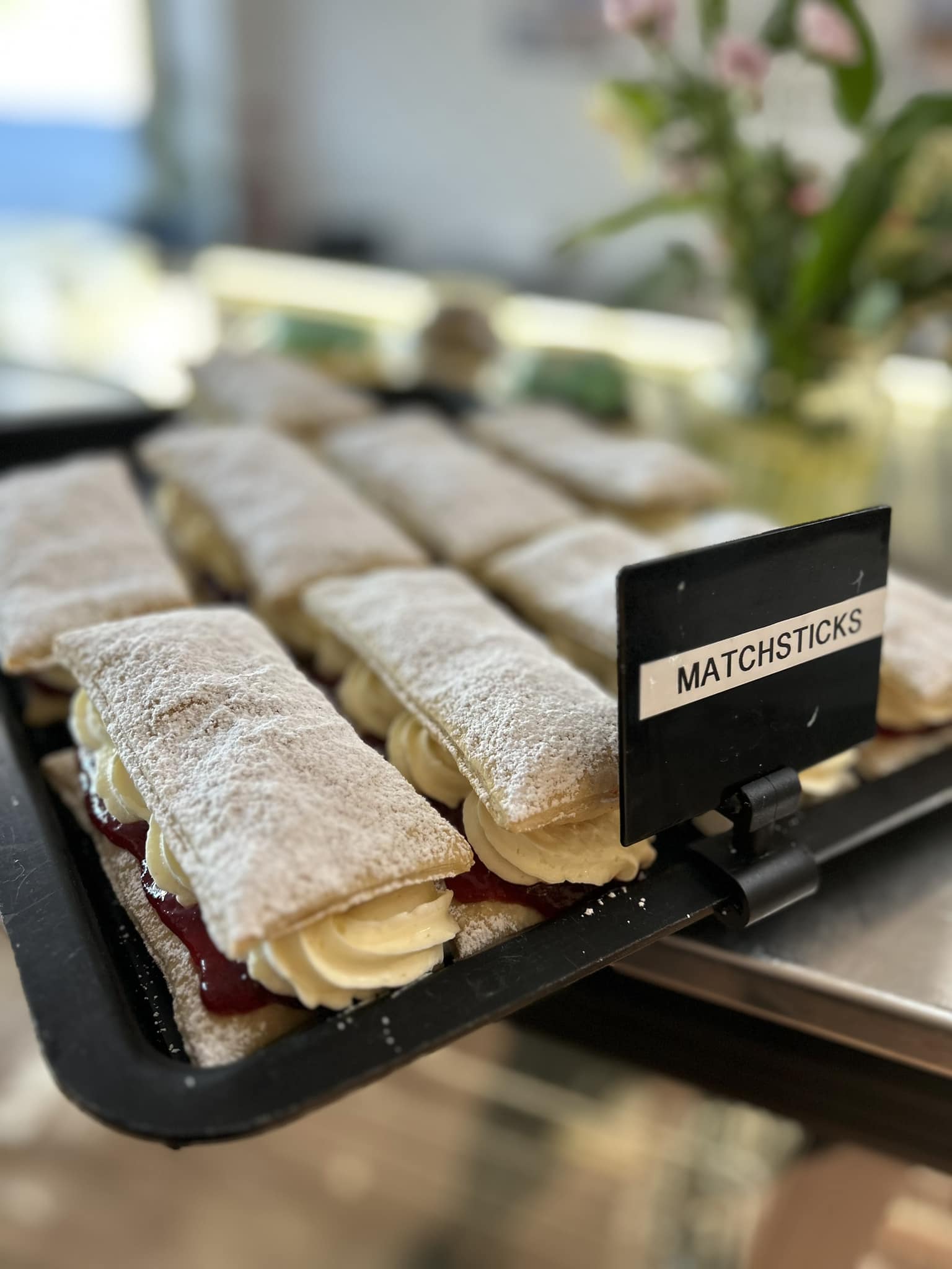 Matchsticks, a jam and cream pastry slice, lined up on a display tray